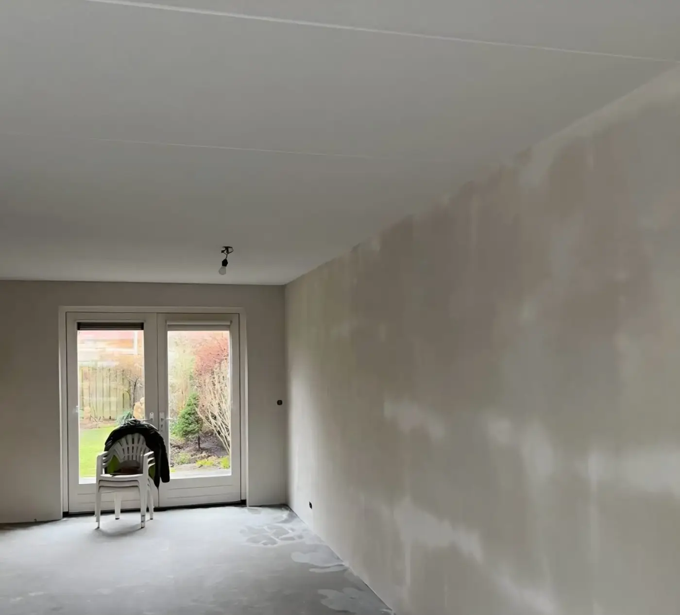 Lange woonkamerwand behangklaar gestuukt in een eengezinswoning