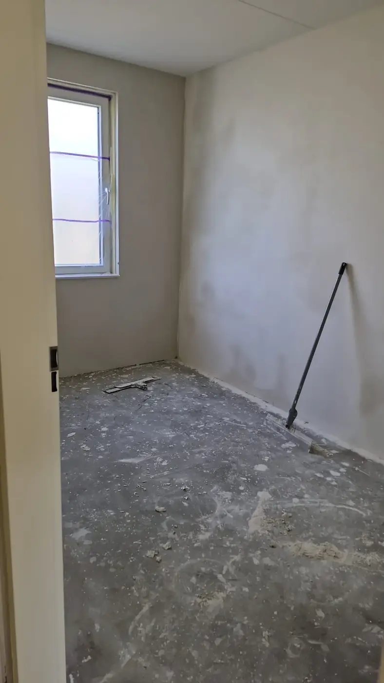 Kleine slaapkamer met vers gestuukte wanden, klaar voor de afwerking